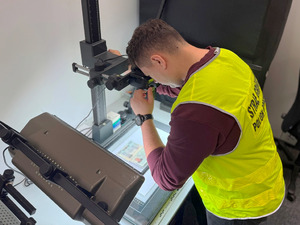 Technik kryminalistyki fotografuje dokument. Technik kryminalistyki fotografuje dokument.