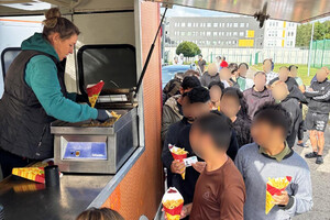 Cudzoziemcy odbierają posiłek. Cudzoziemcy odbierają posiłek.