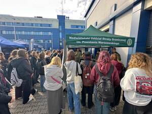 Młodzież stoi przy stoisku promocyjnym  NwOSG. Młodzież stoi przy stoisku promocyjnym  NwOSG.