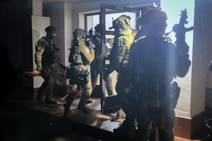 Funkcjonariusze Straży Granicznej stoją przed wejściem do budynku. Funkcjonariusze Straży Granicznej stoją przed wejściem do budynku.