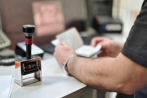 Po lewej stronie stempel kontrolerski, w gębi funkcjonariusz trzyma paszport. Po lewej stronie stempel kontrolerski, w gębi funkcjonariusz trzyma paszport.