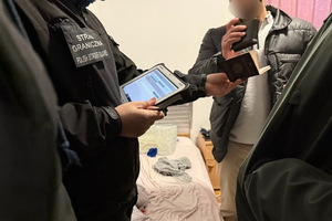 Funkcjonariusz wprowadza dane do urządzenia mobilnego. Funkcjonariusz wprowadza dane do urządzenia mobilnego.