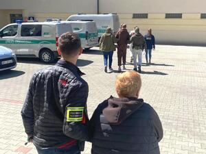 Funkcjonariusze prowadzą zatrzymanych. Funkcjonariusze prowadzą zatrzymanych.