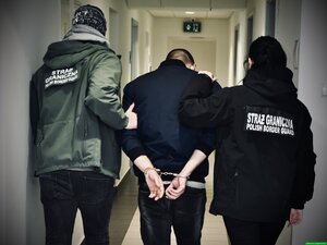 Funkcjonariusze prowadzą mężczyznę. Funkcjonariusze prowadzą mężczyznę.