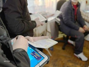 Funkcjonariusz sprawdza dokumenty za pomocą urządzenia mobilnego. Funkcjonariusz sprawdza dokumenty za pomocą urządzenia mobilnego.